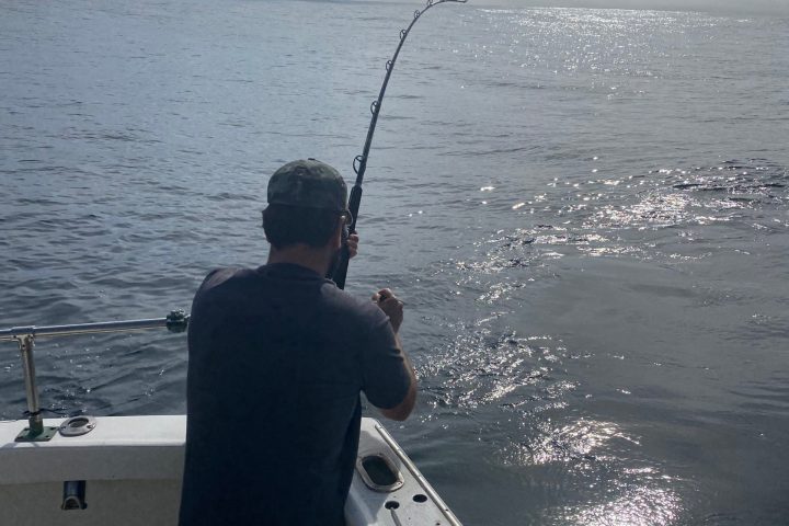 a man standing next to a body of water