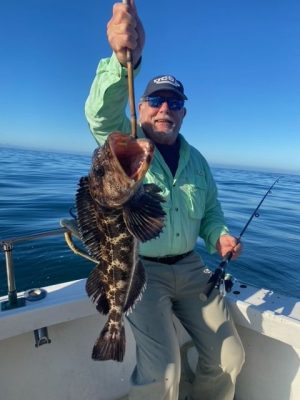 a person holding a fish on a boat in a body of water